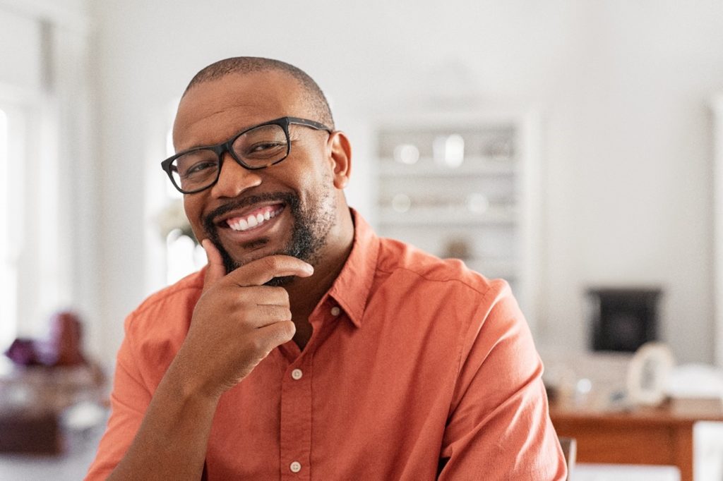 Closeup of mature man smiling in orange shirt