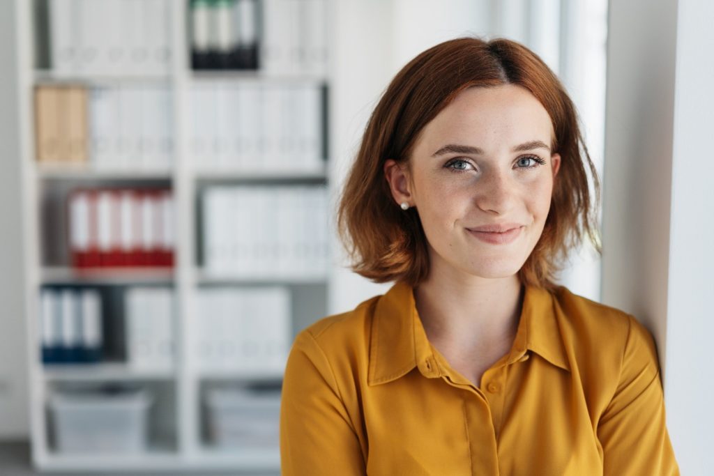 Portrait of woman in orange shirt smiling