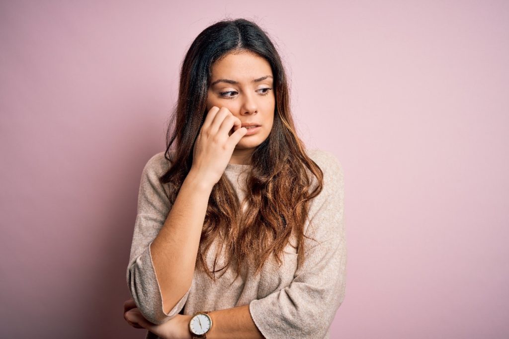 Woman looking worried while biting her nails