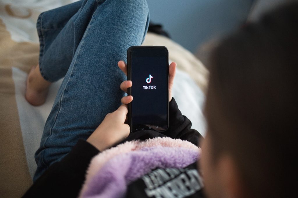 Woman lying down while logging into TikTok app