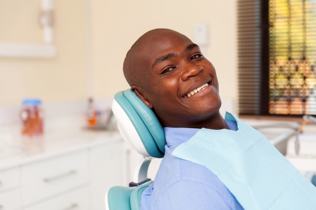 Man smiling in dentist's treatment chair during checkup