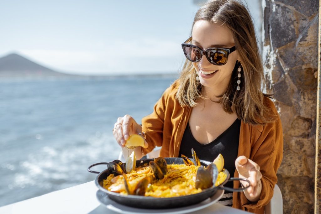 Woman smiling while eating on beach