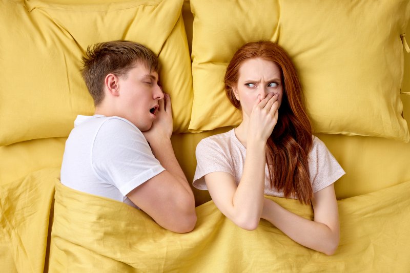 women pinching nose because of morning breath 