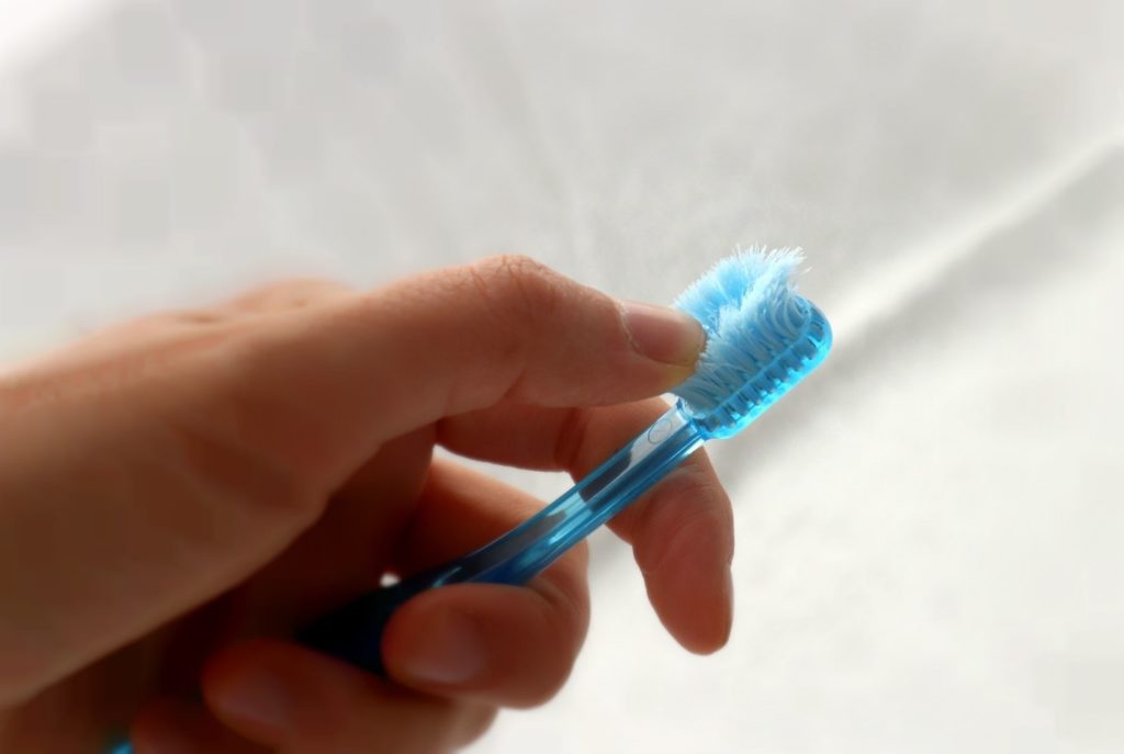 Patient looking at frayed toothbrush