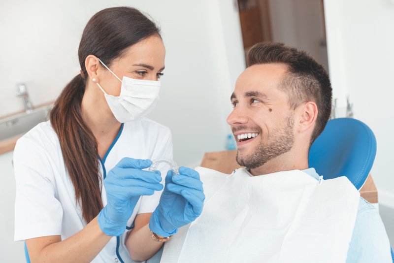 a dentist showing a patient Invisalign trays in Arlington Heights