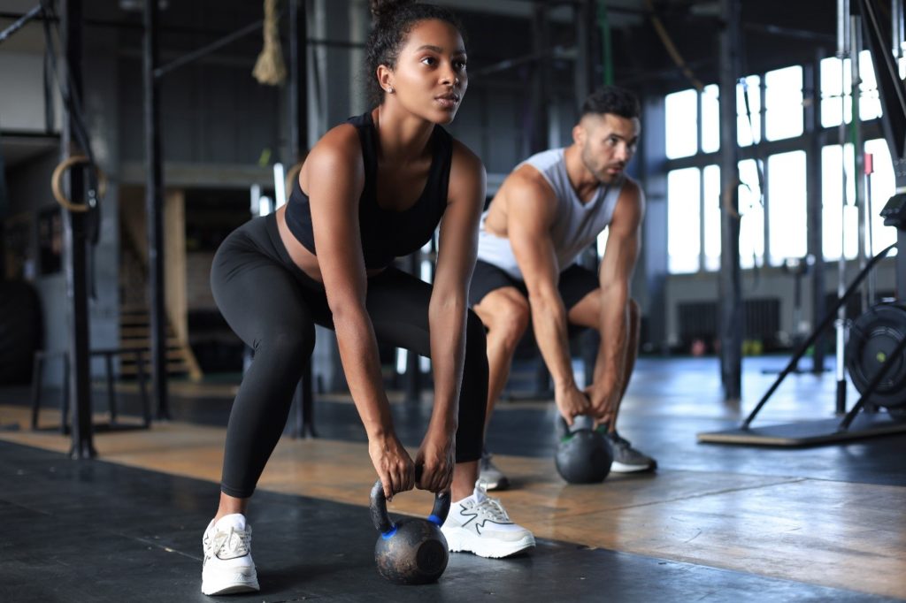 Man and woman lifting weights at the gym