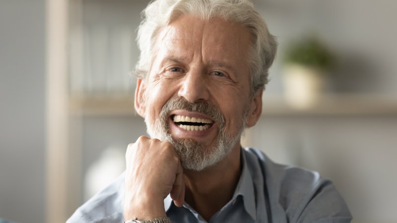 man smiling after getting dentures 