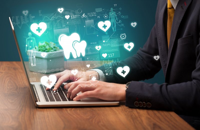 person at computer with various dental icons