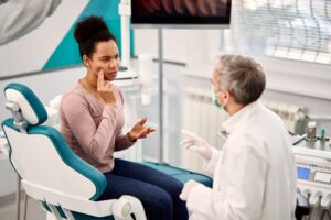 Dental patient explaining her symptoms to her dentist