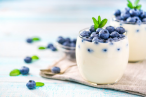 Yogurt and blueberries aesthetically arranged in a glass cup