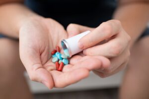 person pouring pills into their hand